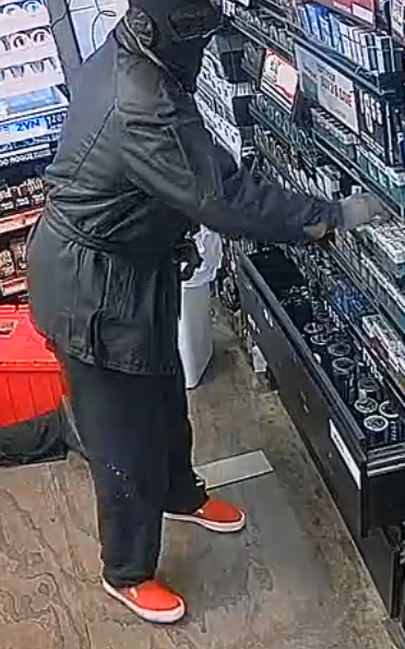 Another image taken from security footage shows the gunman from a different angle as he takes cigarettes from shelves inside the store.